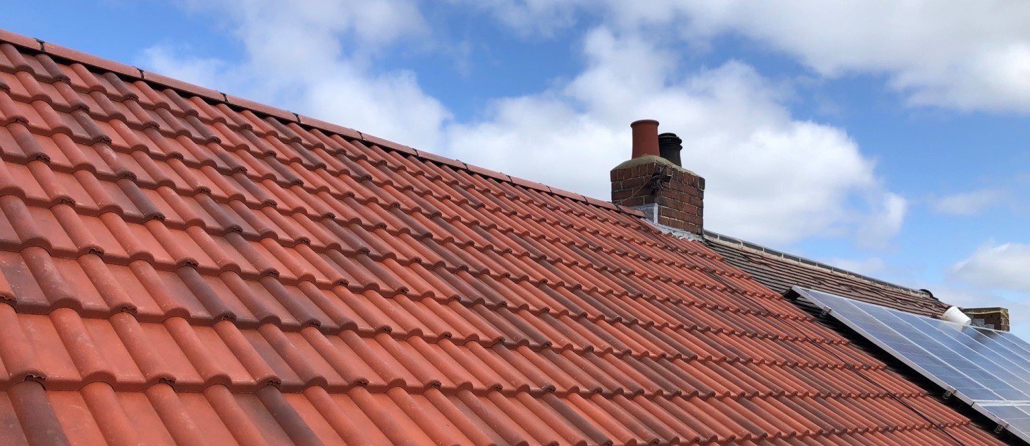 Two brick chimney stacks repointed and flashed on a completed red pantile roof