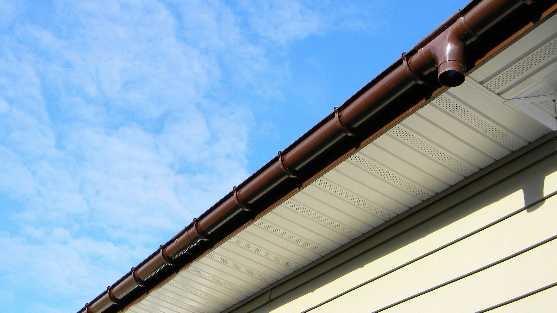 Vented white soffit boards fitted beneath the eaves with brown guttering above