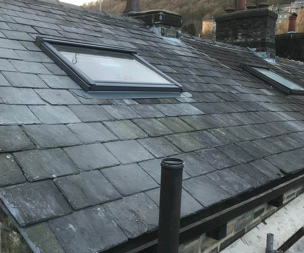 Lead flashing dressed neatly around newly fitted rooflights on a natural slate roof