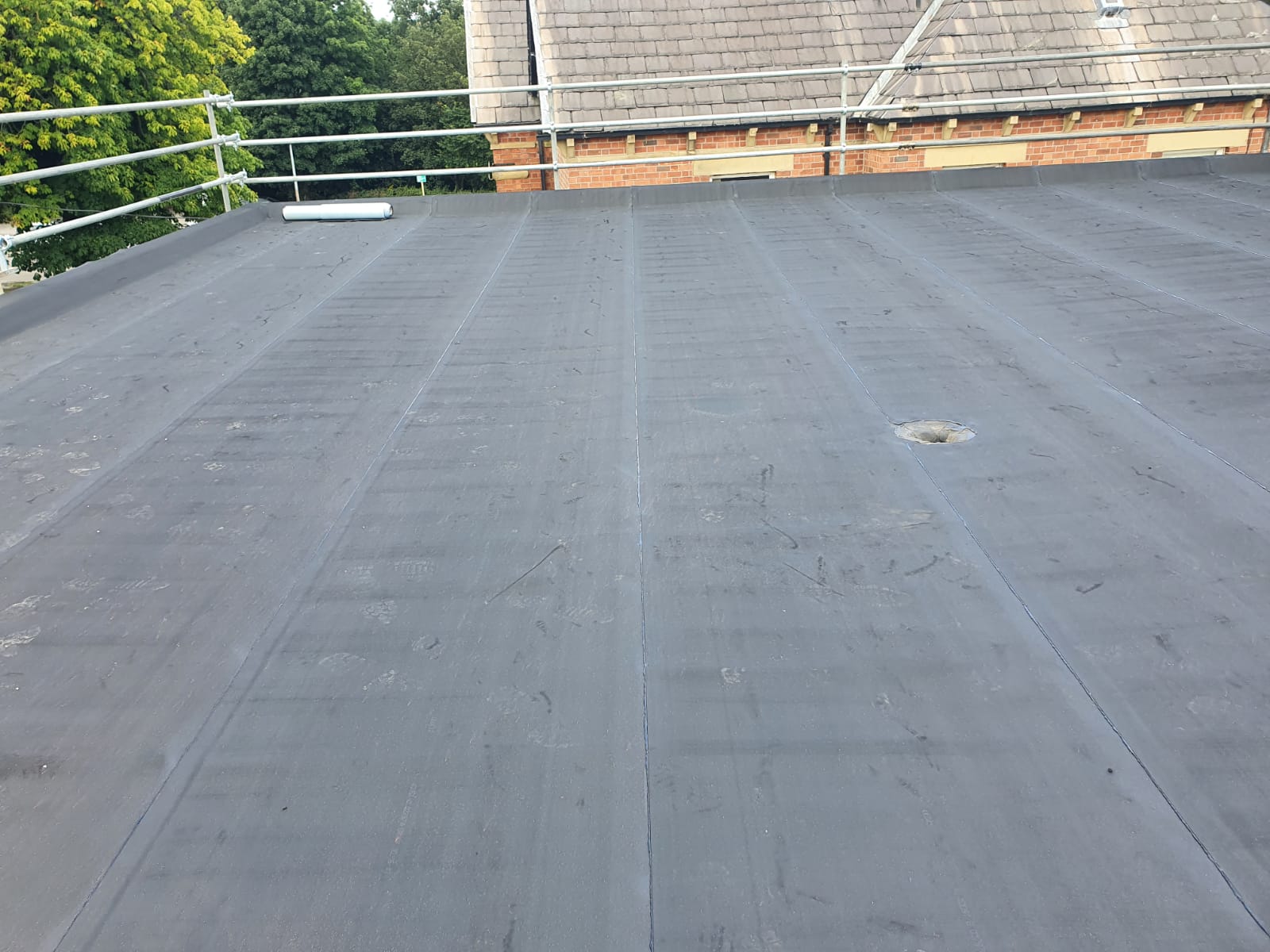 Completed EPDM rubber flat roof with a fully welded membrane and formed outlet detail